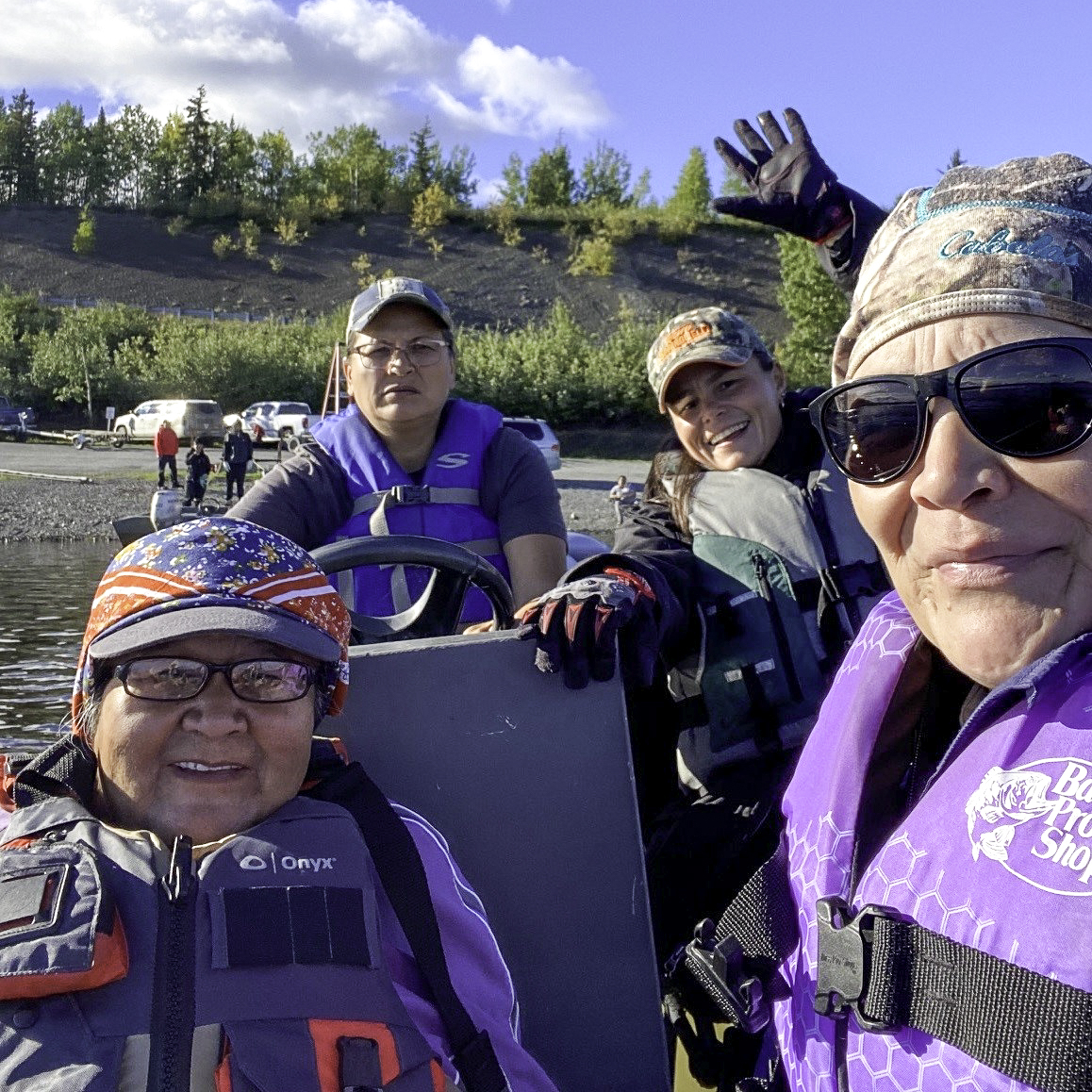 Happy Minto women in a boat on Minto Lakes waving